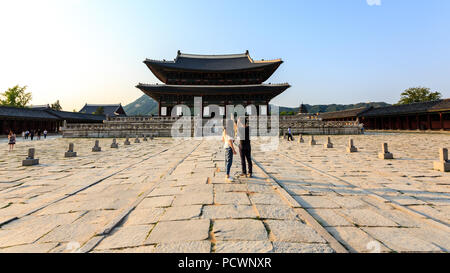 Seoul, South Korea - June 18, 2017: Young couple taking mobile photo in the Gyeongbokgung Palace. Stock Photo