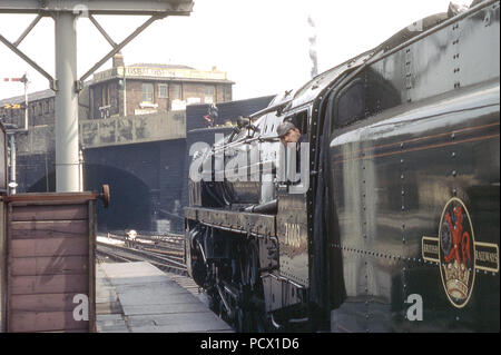 Standard 7P6F Class No 70013 OLIVER CROMWELL waits to depart Preston on a railtour with the driver keeping out an eye for the guard's flag  c. 1968 Stock Photo