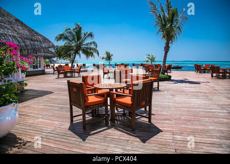 Caffe on tropical island with palm trees and amazing vibrant beach in Maldives. Stock Photo