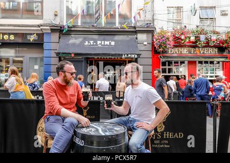 Dublin. 4th Aug, 2018. People enjoy beer outside a bar in downtown Dublin, Ireland, Aug. 3, 2018. The first Friday of every August marks International Beer Day, an event to encourage people to gather with friends and enjoy the taste of beer. Credit: Xinhua/Alamy Live News Stock Photo