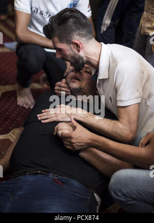 Gaza City, The Gaza Strip, Palestine. 4th Aug, 2018. Brother to the deceased seen mourning during the funeral.Funeral of Ahmed Yaghi, a 25year old Palestinian who was shot dead by Israeli troops during clashes along the border in Gaza. Credit: Mahmoud Issa/SOPA Images/ZUMA Wire/Alamy Live News Stock Photo