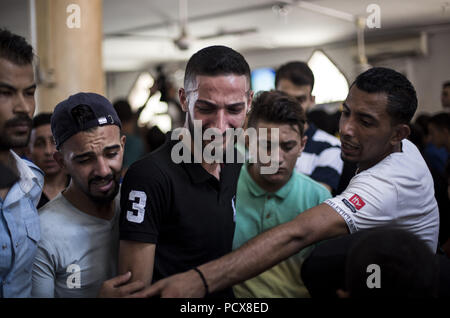 Gaza City, The Gaza Strip, Palestine. 4th Aug, 2018. Relatives of the deceased seen mourning during the funeral.Funeral of Ahmed Yaghi, a 25year old Palestinian who was shot dead by Israeli troops during clashes along the border in Gaza. Credit: Mahmoud Issa/SOPA Images/ZUMA Wire/Alamy Live News Stock Photo
