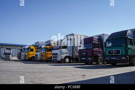 (180804) -- HORGOS, Aug. 4, 2018 (Xinhua) -- Photo taken on Aug. 4, 2018 shows trucks from Kazakhstan parking at a foreign trade company in Horgos, northwest China's Xinjiang Uygur Autonomous Region, Aug. 4, 2018. The trade at the China-Kazakhstan Horgos International Border Cooperation Center enters a busy season since the beginning of the summer tourism peak.  (Xinhua/Li Mengjiao)(gxn) Stock Photo