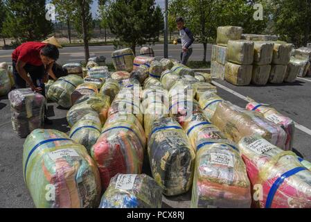 (180804) -- HORGOS, Aug. 4, 2018 (Xinhua) -- Traders from Kazakhstan pack cargo at the China-Kazakhstan Horgos International Border Cooperation Center in Horgos, northwest China's Xinjiang Uygur Autonomous Region, Aug. 4, 2018. The trade at the China-Kazakhstan Horgos International Border Cooperation Center enters a busy season since the beginning of the summer tourism peak. (Xinhua/Hu Huhu)(gxn) Stock Photo