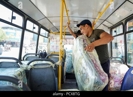 (180804) -- HORGOS, Aug. 4, 2018 (Xinhua) -- A trader from Kazakhstan carries cargo in Horgos, northwest China's Xinjiang Uygur Autonomous Region, Aug. 4, 2018. The trade at the China-Kazakhstan Horgos International Border Cooperation Center enters a busy season since the beginning of the summer tourism peak. (Xinhua/Li Mengjiao)(gxn) Stock Photo