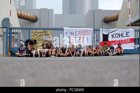 Lippendorf, Germany. 04th Aug, 2018. Activists of the action group 'Kohle erSetzen' protest with a sit-in in front of a banner with the inscription 'Fossil-fuel phase-out now' on a street in front of the Lippendorf power station. The demand behind this campaign is the immediate coal phase-out. Participants of a climate camp have been demonstrating for a week against the demolition of the village of Poedelwitz in the immediate vicinity of the power plant. Credit: Sebastian Willnow/dpa-Zentralbild/dpa/Alamy Live News Stock Photo