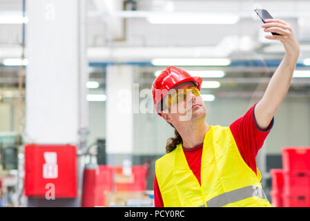 Factory worker taking selfie in a factory Stock Photo