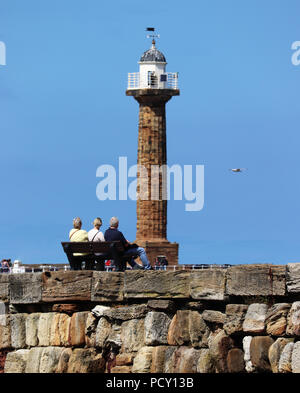 Old folks relax on the harbour wall at Whitby Stock Photo