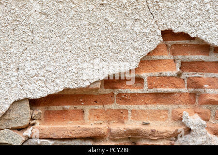 Old damaged plaster on a red brick wall. Stock Photo