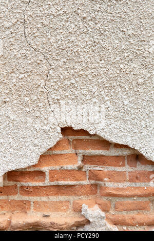 Old damaged plaster on a red brick wall. Stock Photo