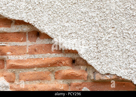 Old damaged plaster on a red brick wall. Stock Photo