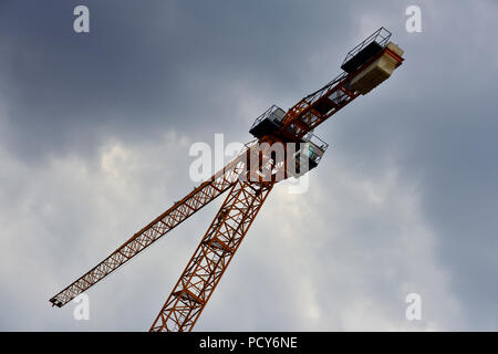 High rise tower construction crane against dark foreboding sky Stock Photo