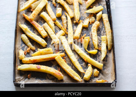 Roasted parsnip with parmesan on baking tray Stock Photo