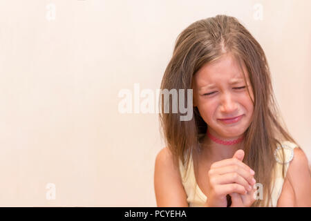 The little girl is sincerely crying. The concept of child insult, depression and misunderstanding. Stock Photo