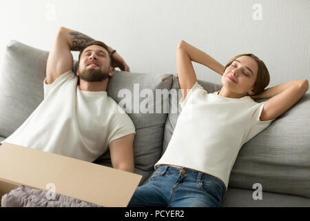 Relaxed couple lying on sofa happy to move in Stock Photo