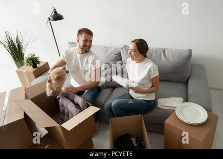 Happy young couple having fun moving to new flat Stock Photo