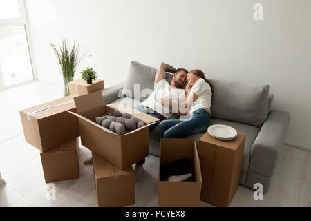 Loving husband lying together on sofa in first shared flat Stock Photo