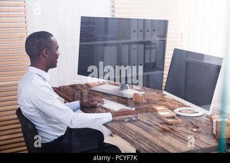 Happy Young Businessman Using Computers In The Office Stock Photo