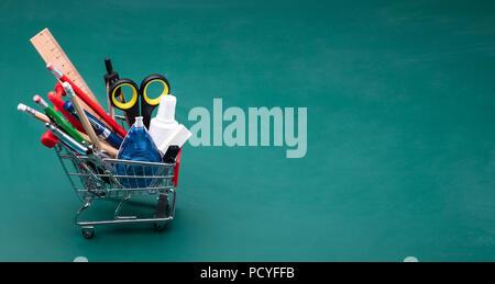 Cart With Various School Supplies On Desk In Classroom Stock Photo