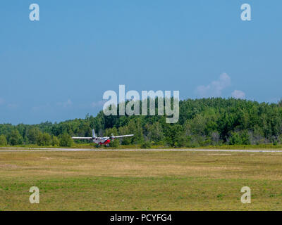 Light private plane is landing on a small airfield on a sunny summer day. Stock Photo