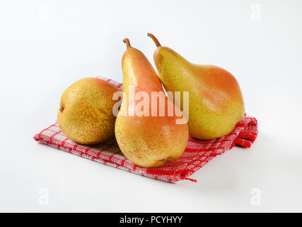 three ripe pears on checkered dishtowel Stock Photo