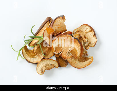 handful of dried mushrooms and fresh rosemary on white background Stock Photo