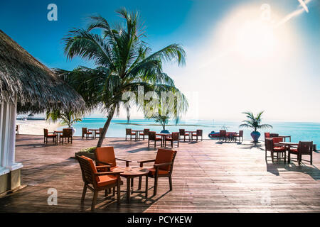 Caffe on tropical island with palm trees and amazing vibrant beach in Maldives. Stock Photo