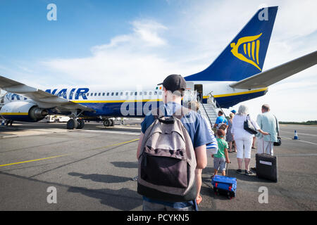 Ryanair passenger with a backpack as carry on hand luggage boarding a Ryanair plane after paying extra for priority boarding. Stock Photo