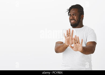 No thanks, I refuse. Portrait of displeased intense attractive african-american man with beard and moustache, pulling palms towards camera in stop or  Stock Photo