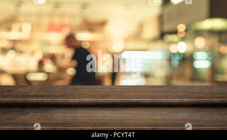Empty step dark wood table top ( food stand ) with blur customer dining at cafe restaurant background bokeh light,Mock up for display or montage of pr Stock Photo