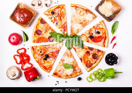 selection of Assorted pieces pizza on white background and ingredients. Pepperoni, Vegetarian and Seafood Pizza. Stock Photo