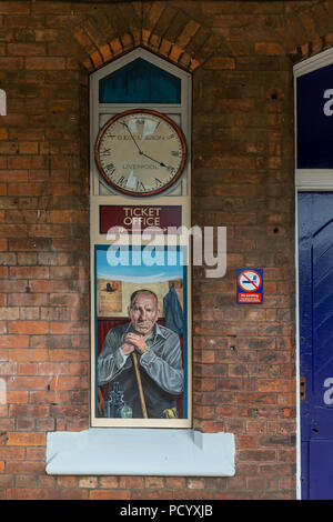 A no-longer used window in the building at the Historic Railway Station of Padgate has a painting of local character actor, Pete Postlethwaite, Warrin Stock Photo