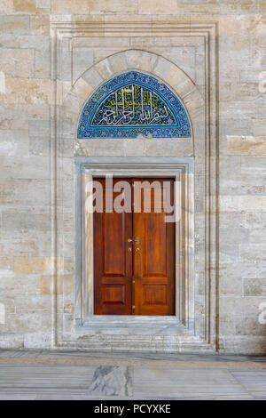 Wooden engraved door on stone wall and tiled marble floor, Sulaymaniye Mosque, Istanbul, Turkey Stock Photo
