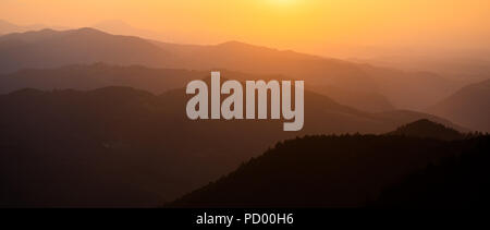 Panoramic view of distant misty mountains during sunset Stock Photo