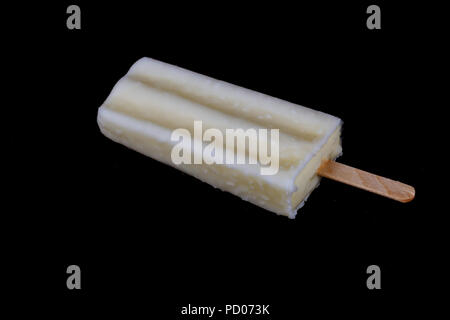 Frozen white fruity yogurt on a stick with missing bite, isolated on black Stock Photo