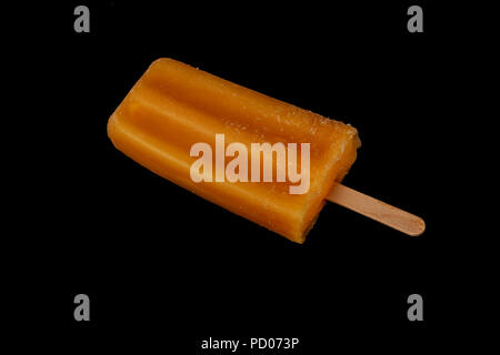 Orange fruity yogurt on a stick popsicle isolated on isolated on black background Stock Photo