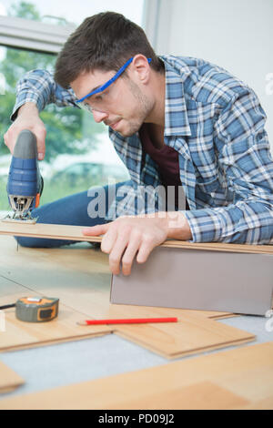 assembling furniture from chipboard using a cordless screwdriver Stock Photo
