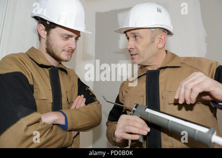 young construction worker installing window in house Stock Photo