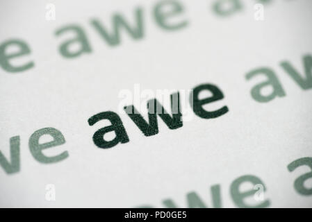 word awe printed on white paper macro Stock Photo