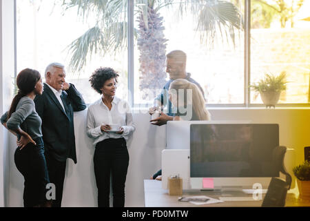 Group of business people having a casual discussion during coffee break. Business team having a coffee break. Stock Photo