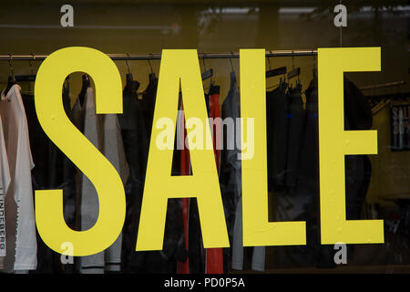 Yellow Sale Sign on Shop Window Stock Photo