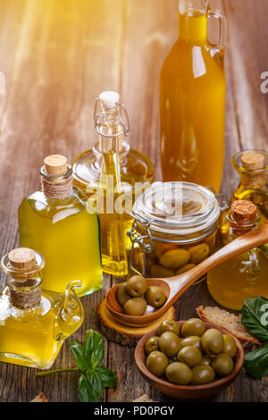 Extra virgin healthy olive oil with green olive on wooden background Stock Photo