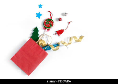 Christmas gifts falling from the red shopping bag, holiday presents isolated on white background, free copy space. Stock Photo