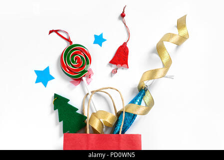 Christmas gifts falling from the red shopping bag, holiday presents isolated on white background, holiday concept Stock Photo