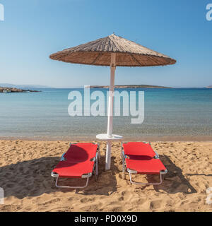 Umbrellas with sunbeds on beautiful sandy Santa Maria beach with turquoise sea water, Paros island, Greece Stock Photo