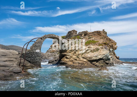Old arched stone bridge in the beautiful town of Chora on Andros island, Cyclades, Greece Stock Photo