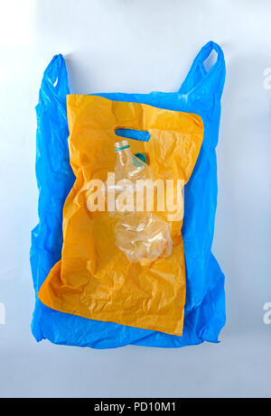 yellow and blue plastic bag plastic bottle on a gray background Stock Photo
