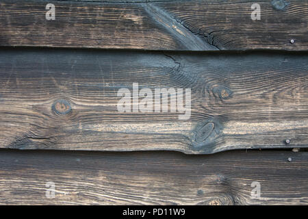 Closeup of weathered wall made from dark boards of wood with knots Stock Photo