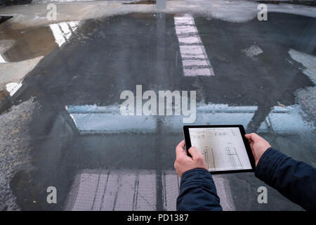 Detail of male engineer using digital tablet at construction site, only arms and hands are visible Stock Photo