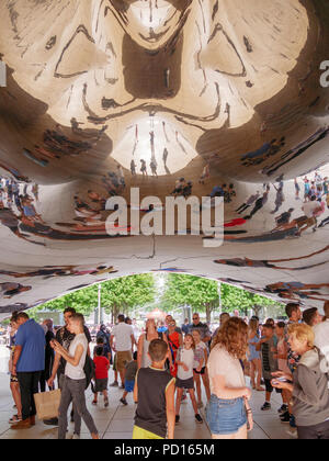 Tourists underneath the Cloud Gate sculpture in Chicago's Millennium Park. Stock Photo